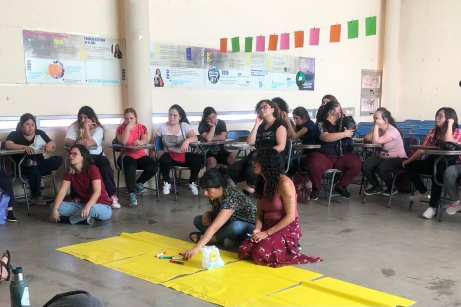 Foto del primer encuentro de Dislocadas en dic. 2023, se ven jóvenes y mujeres conversando en un taller en un aula de la universidad