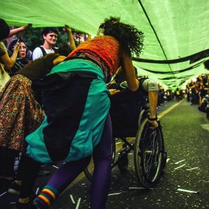 Foto de Maxi bajo la bandera de la marcha de salud mental.